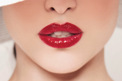 Young woman with very red lips after lip blush treatment