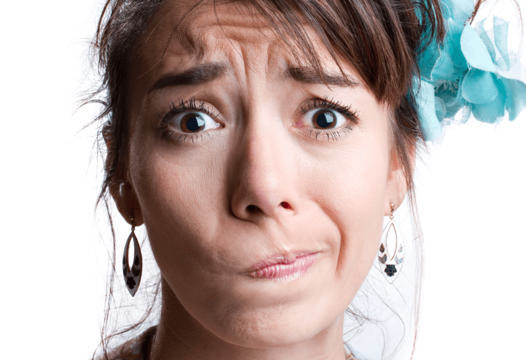 Headshot of a white woman wearing earrings looking worried